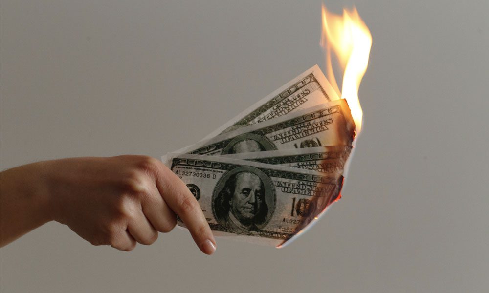 Auto Insurance Gift Card Promotion - Hand Holding One Hundred Dollar Bills On Fire